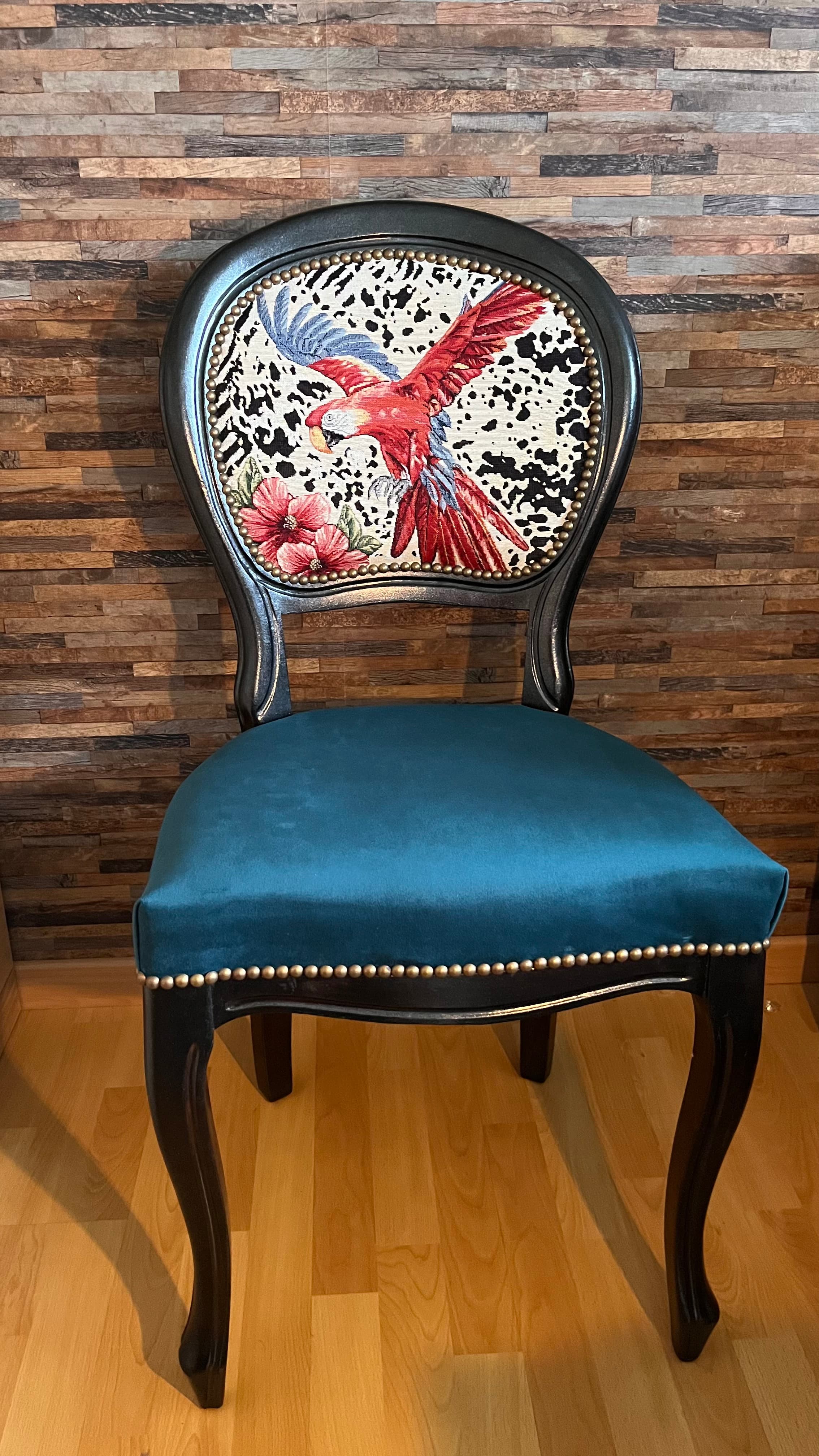 Siège restauré : bois noir, assise velours bleu-vert et dossier tapissé d’un motif perroquet, finition clous décoratifs.